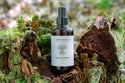 Bottle of Raw Root Rescue Tonic on a natural background with moss and wood.