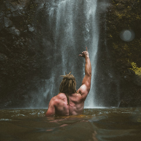 Dreadlocks beneath a waterfall