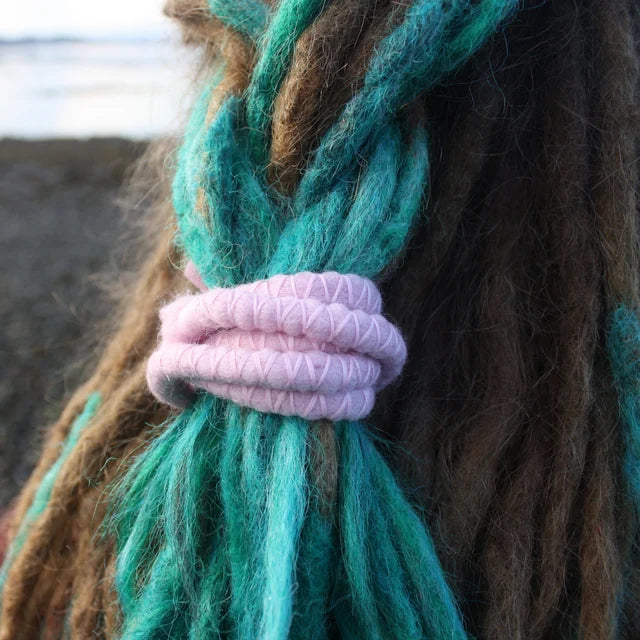 Pink spiral dread tie holding turquoise dreadlocks